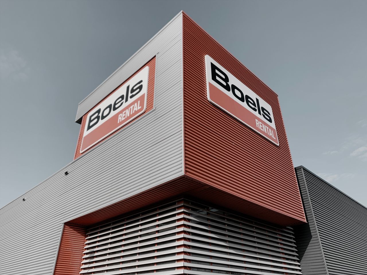 Low angle view of modern commercial building with Boels Rental signage in Alkmaar.